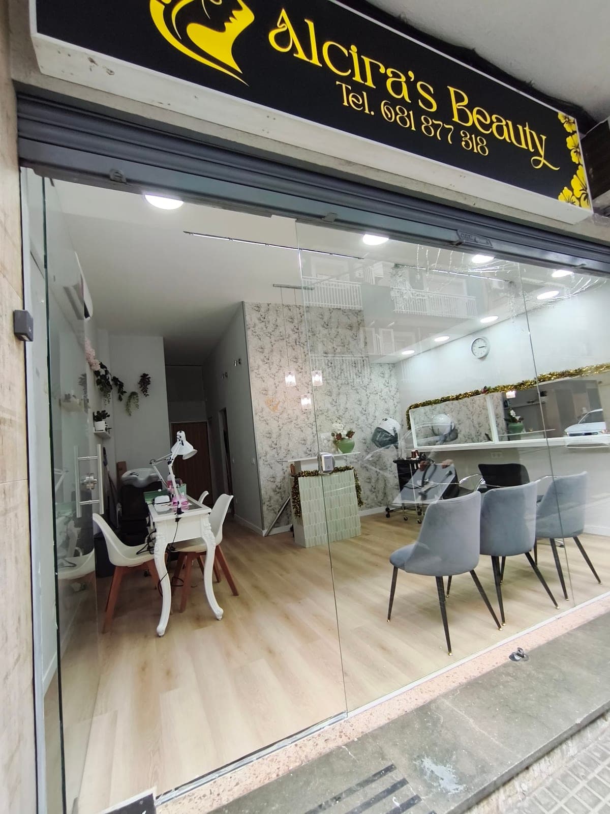 Fachada de Alcira's Beauty: rótulo negro con letras doradas y escaparate de cristal